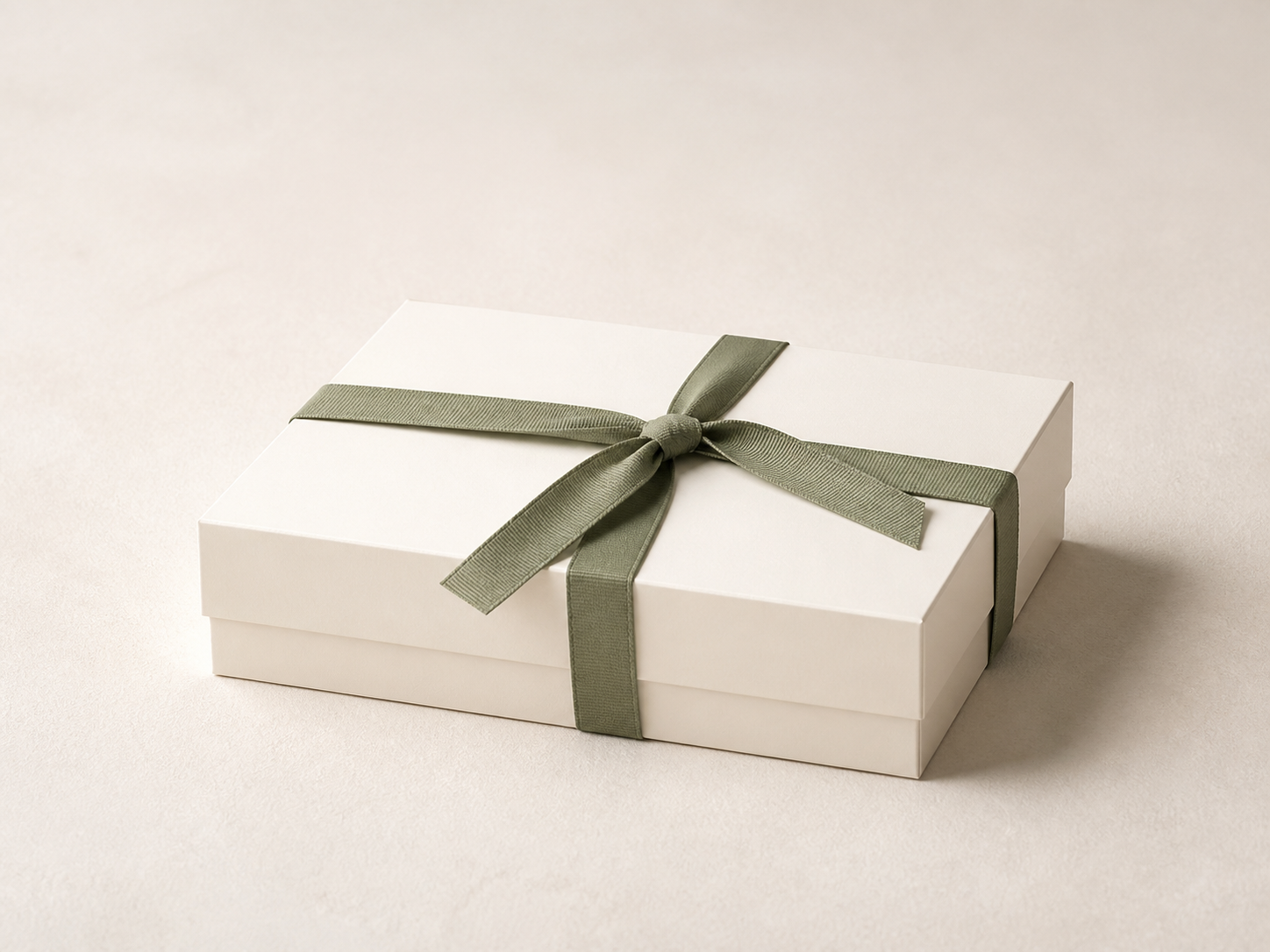GRAVIA warm-white gift box with a sage ribbon